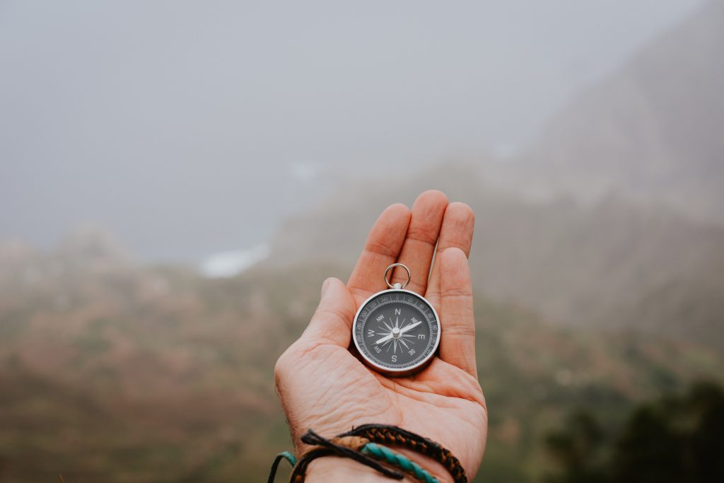 looking at the compass to figure out right direction. foggy valley and mountains in background. santo antao. cape cabo verde